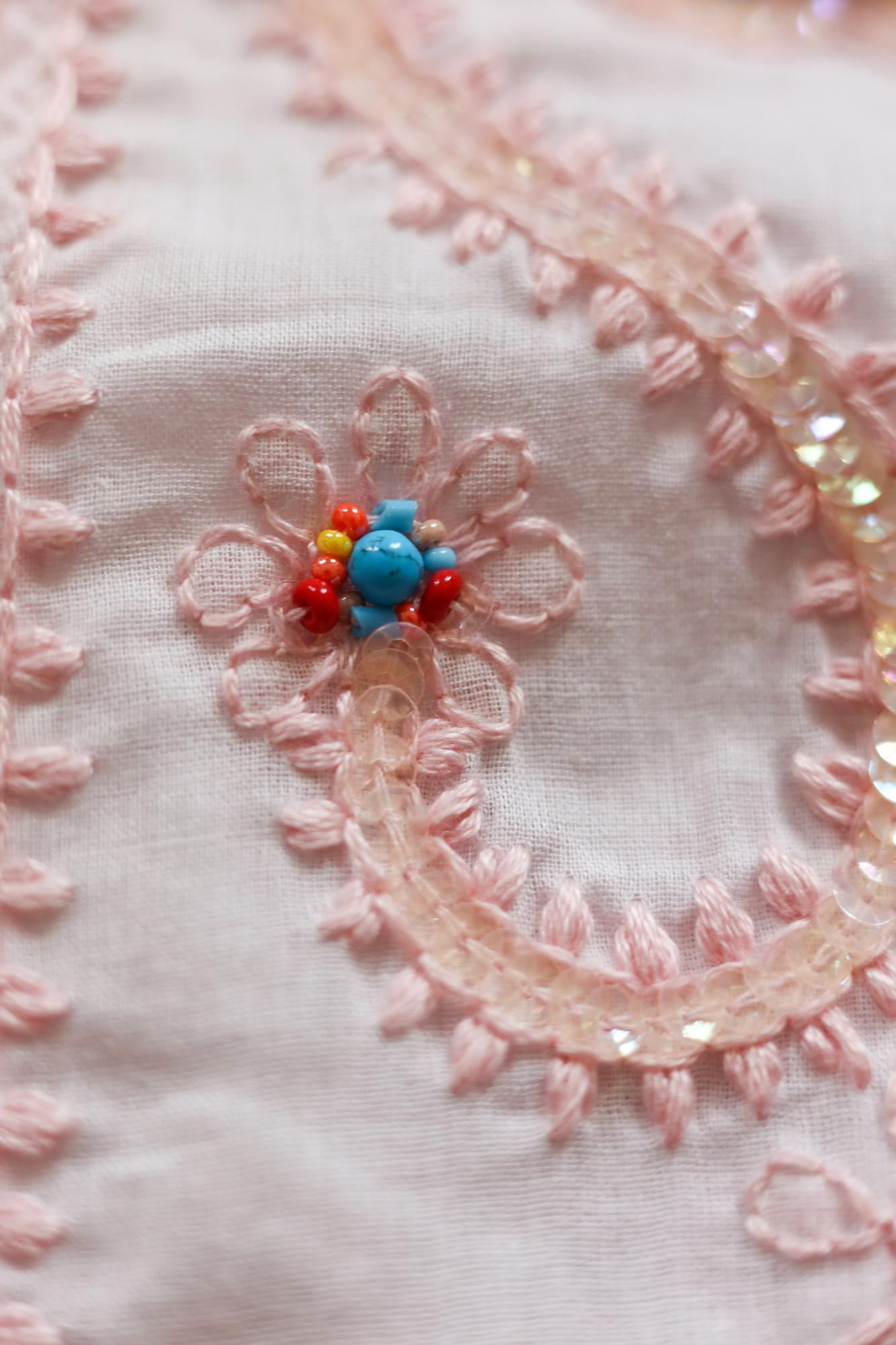 Close-up of pastel embroidered patch on linen